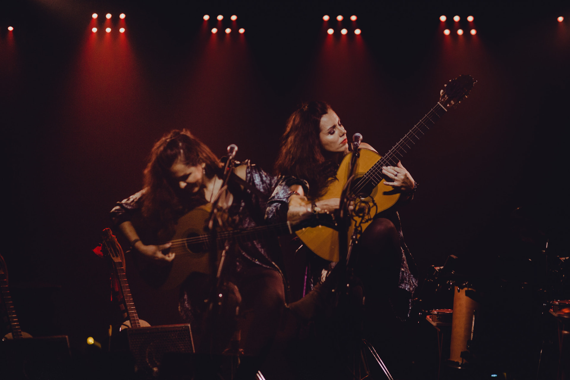 Carolina Zingler e violinista em palco com luzes vermelhas