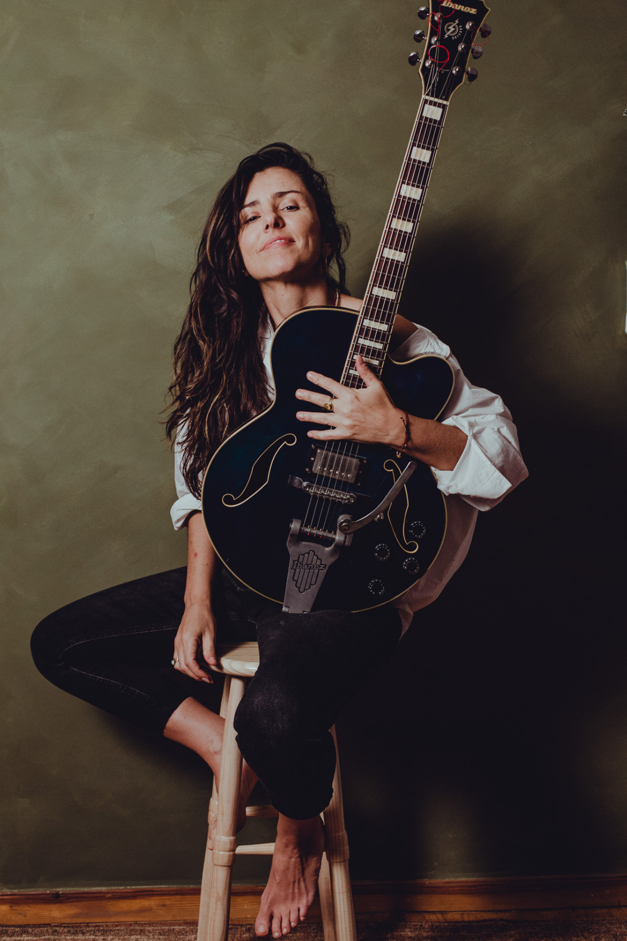 Carolina Zingler com guitarra elétrica semi-acústica em estúdio